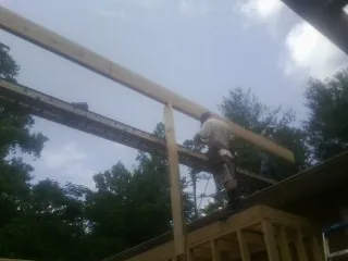 Carpenter setting a ridge beam over a new addition frame — Ice Dam Removal by Roofing Brothers in Glen Hope